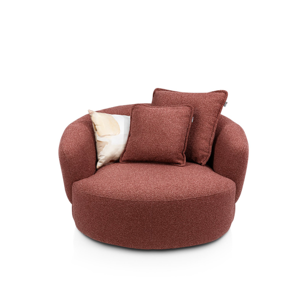Draaifauteuil Cervos van XOOON met ronde vormen, zachte stoffering, verborgen draaivoet en losse sierkussens.